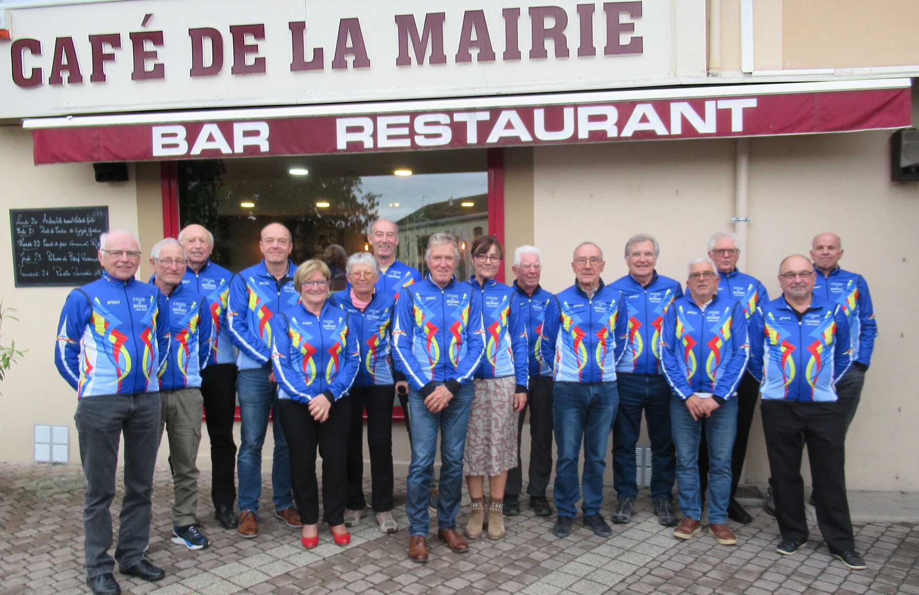 Les membres en maillot bleu et jaune réunis devant le Café de la Mairie